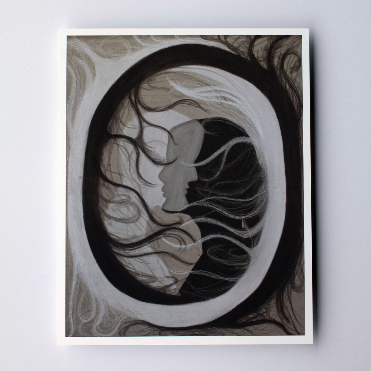 An abstract circle with black and white figures overlapping in the middle on a cream background